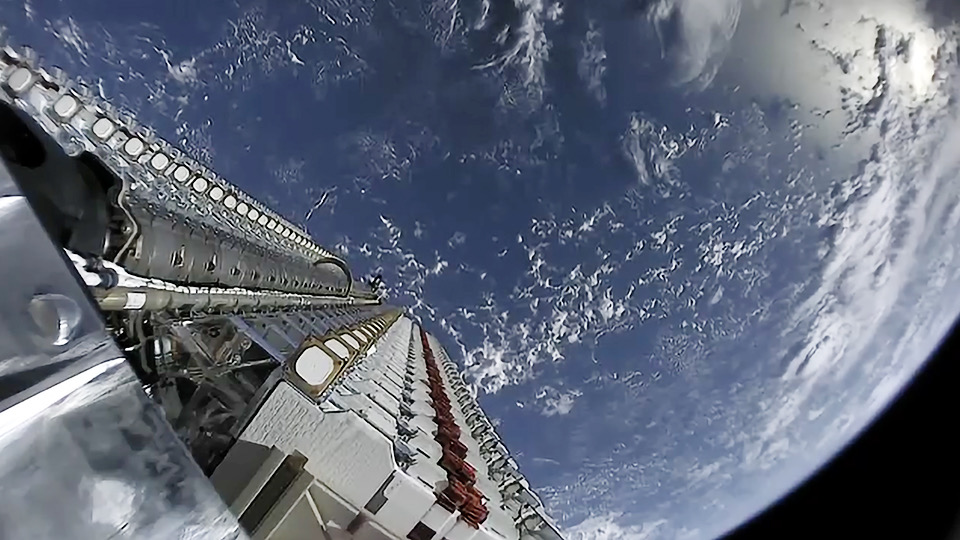 Starlink satellites deploying above Earth in orbit