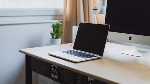 Laptop computer on a neat desk by a window