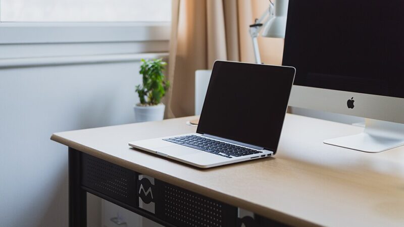 Laptop computer on a neat desk by a window