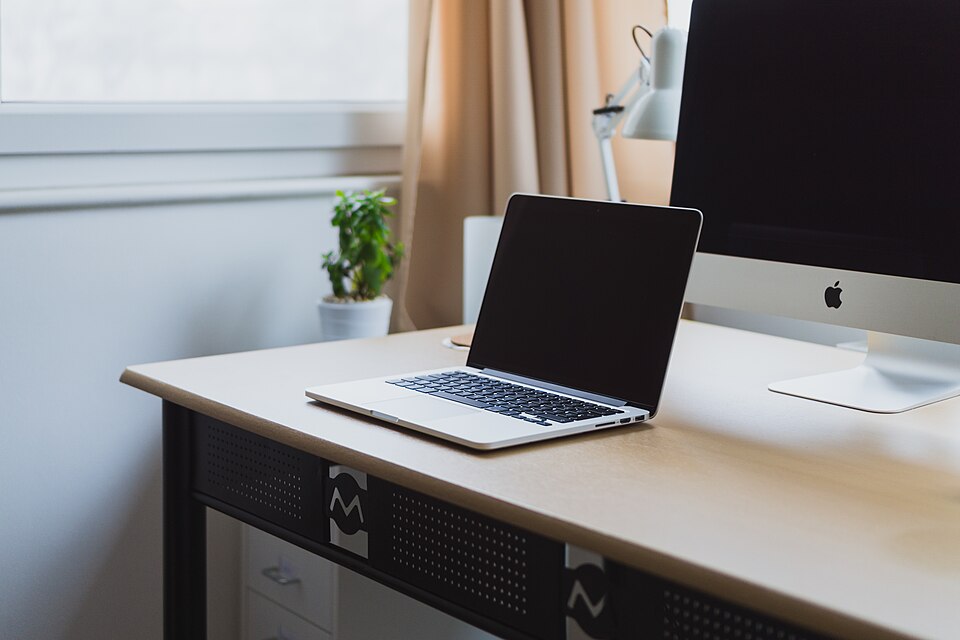 Laptop computer on a neat desk by a window