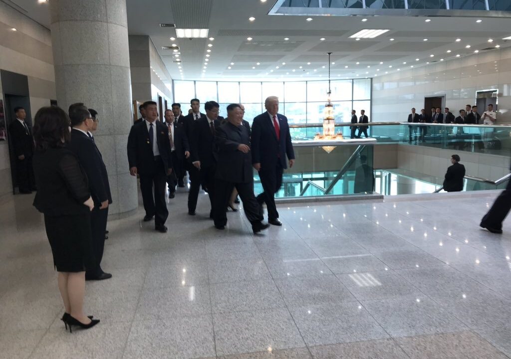 Donald Trump and Kim Jong-un walking with delegations after DMZ summit